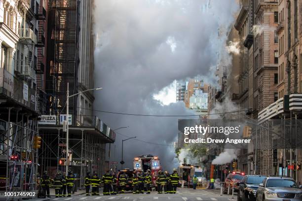 Firefighters work near the scene of a steam pipe explosion on Fifth Avenue near the Flatiron District on July 19, 2018 in New York City. Buildings...