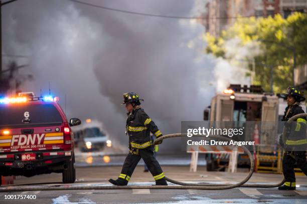 Firefighters work near the scene of a steam pipe explosion on Fifth Avenue near the Flatiron District on July 19, 2018 in New York City. Buildings...