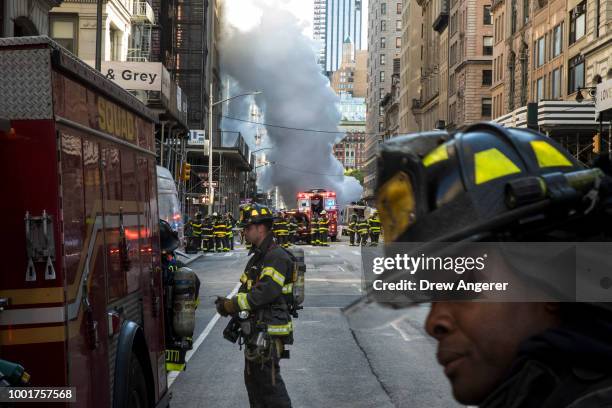 Firefighters work near the scene of a steam pipe explosion on Fifth Avenue near the Flatiron District on July 19, 2018 in New York City. Buildings...