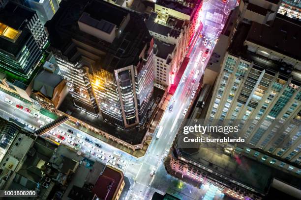 futuristic lights of the streets of a busy city at night glow vividly - cbd stock pictures, royalty-free photos & images