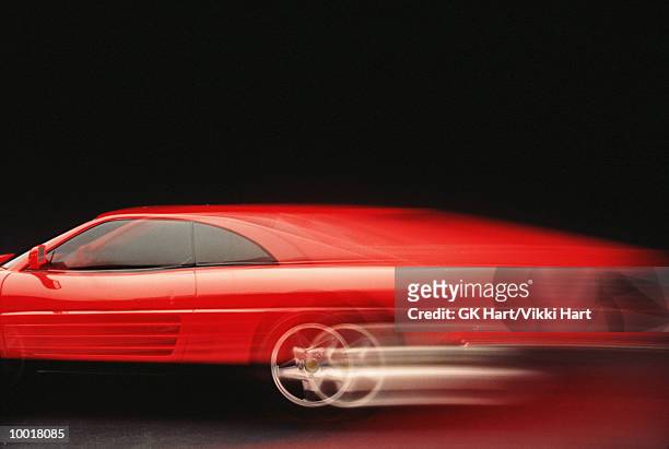 red car (blurred motion) - sportwagen stockfoto's en -beelden