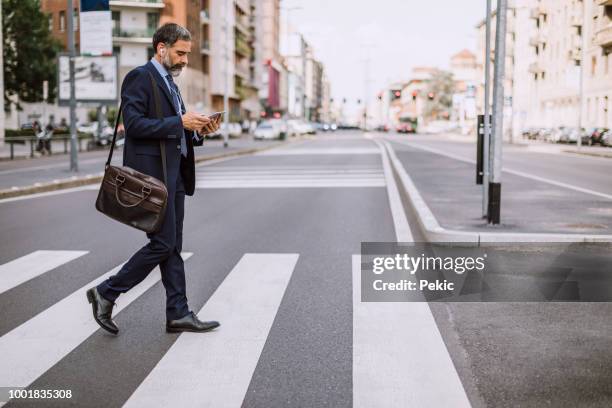 homme d’affaires sur le passage clouté - business man walking photos et images de collection
