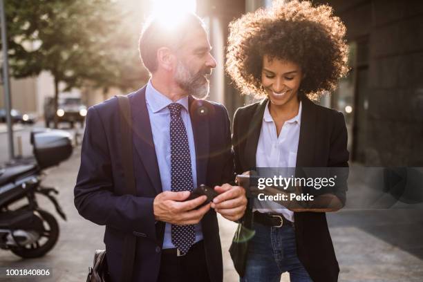 due uomini d'affari che chiacchierano dopo il lavoro - man suit using phone tablet foto e immagini stock