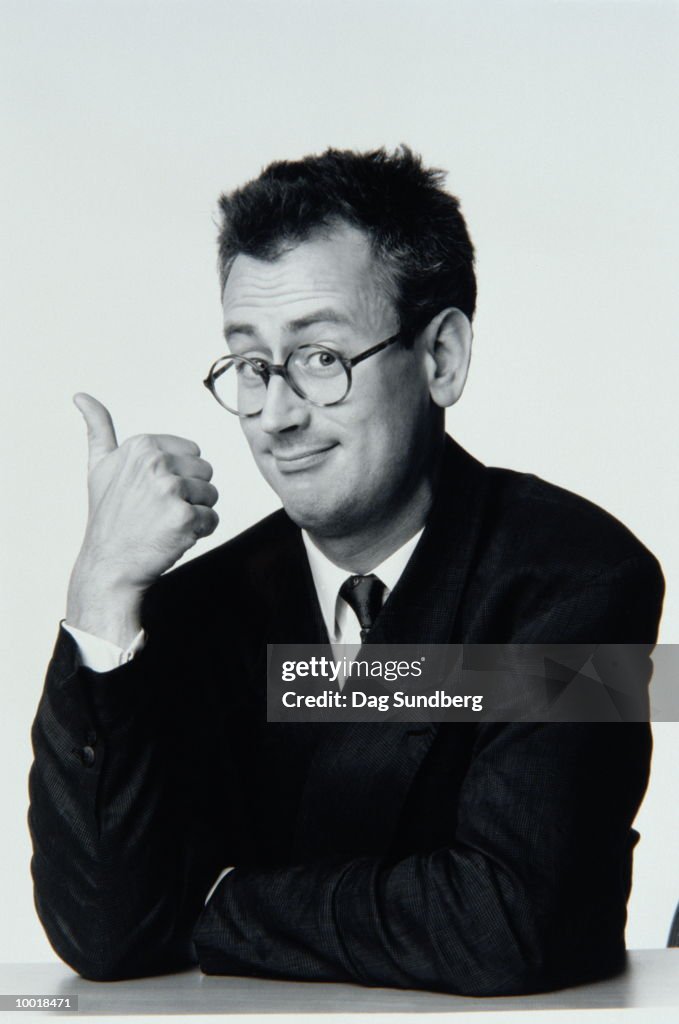 PORTRAIT OF MAN SHOWING THUMBS-UP IN BLACK AND WHITE