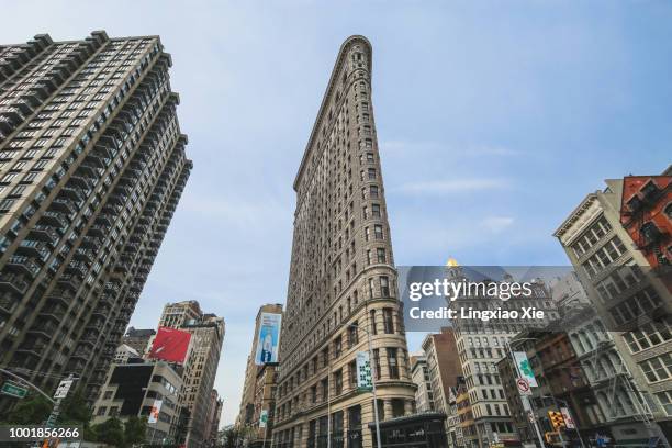 famous flatiron building along fifth avenue and broadway street, manhattan, new york - flatiron building stockfoto's en -beelden