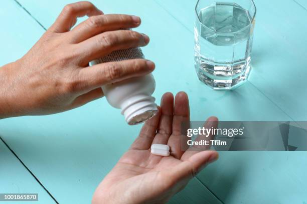 woman's hand on is pouring tablets in her hand. - antioxidants skin stock pictures, royalty-free photos & images