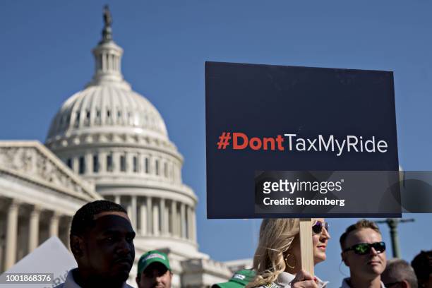 Woman holds a sign opposed to auto tariffs during a news conference on Capitol Hill in Washington, D.C., U.S., on Thursday, July 19, 2018. Members of...