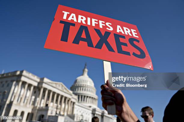 Tariffs Are Taxes" sign is held during a news conference on Capitol Hill in Washington, D.C., U.S., on Thursday, July 19, 2018. Members of Congress...