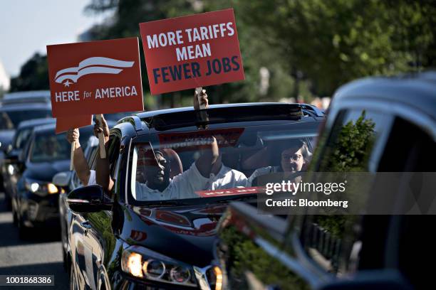 More Tariffs Mean Fewer Jobs" sign is held out of a vehicle while automakers arrive before a news conference on Capitol Hill in Washington, D.C.,...