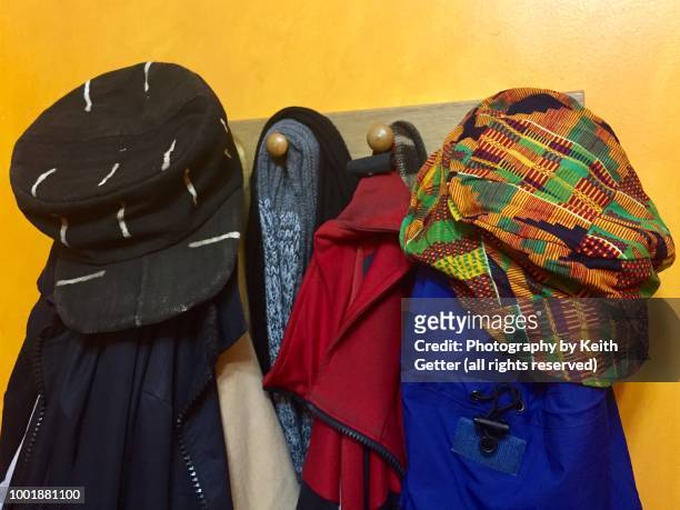 hats, scarves and outerwear hanging on wood pegs  in a home’s vestibule - all shirts stock-fotos und bilder