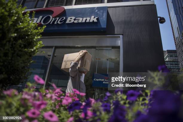 Pedestrian carries a box while passing in front of a Capital One Financial Corp. Bank branch in New York, U.S., on Wednesday, July 19, 2018. Capital...