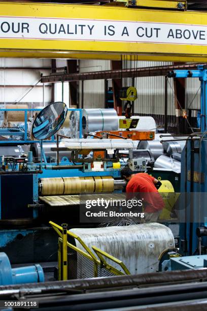 Worker moves material in front of a metal flattening machine at a Stanley Black & Decker Inc. Craftsman Tools manufacturing facility in Sedalia,...