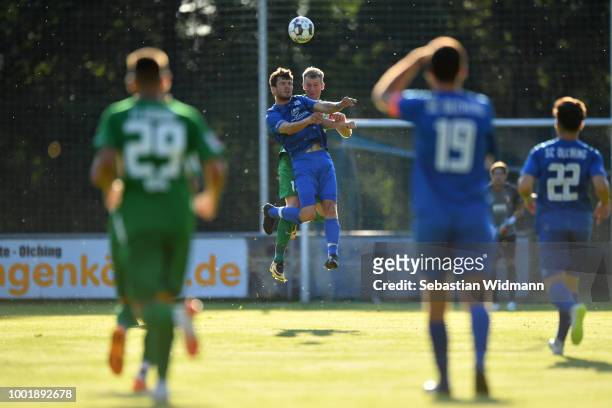 Roman Fuchs of Olching and Jan-Ingwer Callsen-Bracker of Augsburg jump for a header during the pre-season friendly match between SC Olching and FC...