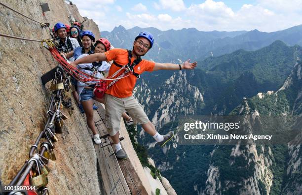 July 19, 2018 : Tourists pose for photos on Chang Kong Plank Road at Huashan Mountain in Huayin City, northwest China's Shaanxi Province, July 18,...