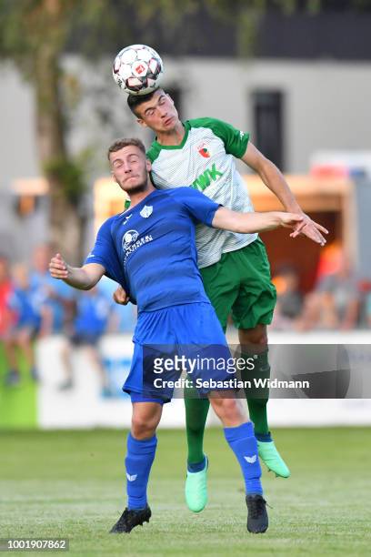 Jozo Stanic of Augsburg and Dominik Amberger of Olching jump for a header during the pre-season friendly match between SC Olching and FC Augsburg on...