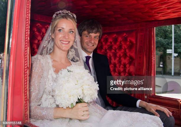Prince Ernst August of Hanover and Ekaterina of Hanover sit in the historical horse carriage after their church wedding at the Marktkirche church in...