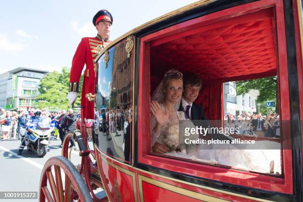 Dpatop - Prince Ernst August of Hanover and his wife Ekaterina of Hanover ride through the city in a historical horse carriage after their church...