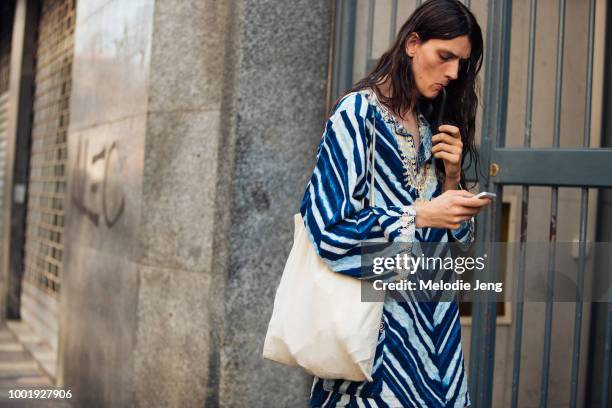 Model Antoni Jankiewicz smokes a pipe and wears a blue stripe kaftan during Milan Men's Fashion Week Spring/Summer 2019 on June 16, 2018 in Milan,...