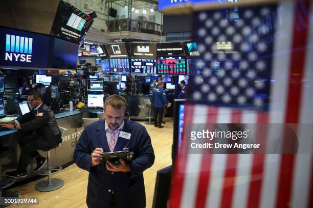 Traders and financial professionals work ahead of the closing bell on the floor of the New York Stock Exchange , July 19, 2018 in New York City....
