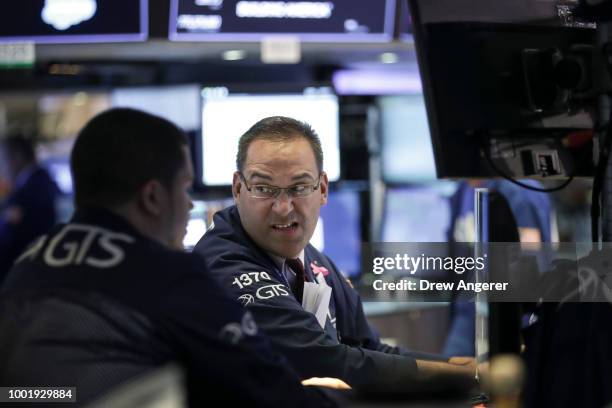 Traders and financial professionals work ahead of the closing bell on the floor of the New York Stock Exchange , July 19, 2018 in New York City....