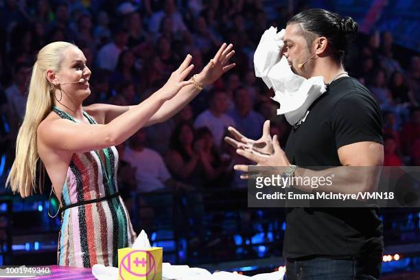 Skier Lindsey Vonn and WWE wrestler Roman Reigns participate in a challenge onstage during the Nickelodeon Kids' Choice Sports 2018 at Barker Hangar...