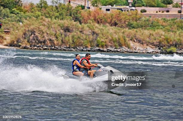 couple jetsking on colorado river - laughlin nevada stock pictures, royalty-free photos & images