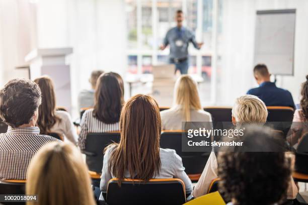 rear view of business people attending a seminar in board room. - person in education stock pictures, royalty-free photos & images
