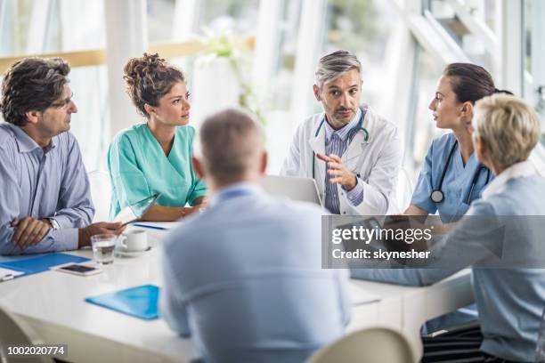 team van artsen en zakenmensen praten over een bijeenkomst bij spreekkamer. - medical conference stockfoto's en -beelden