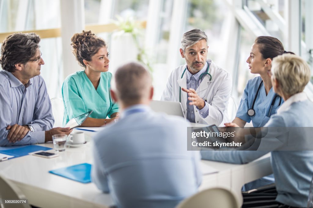 Team of doctors and business people talking on a meeting at doctor's office.