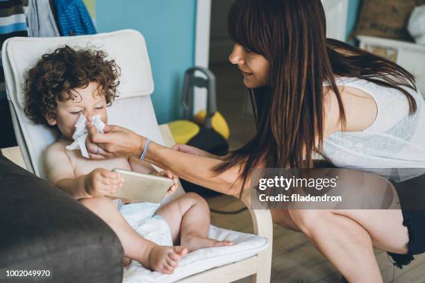 mother helping son to blow his nose - blowing nose stock pictures, royalty-free photos & images