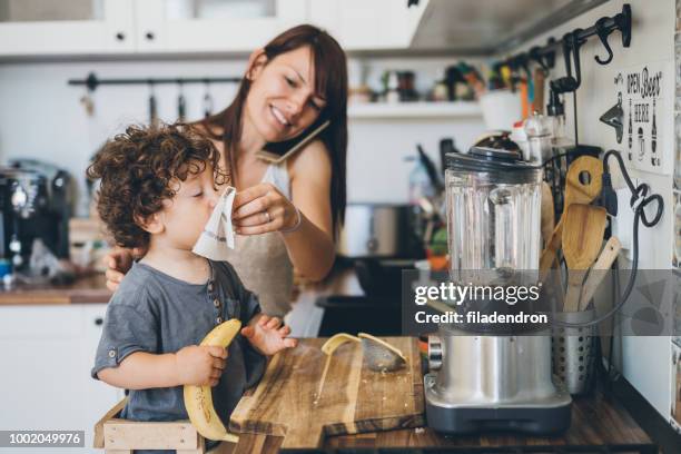 mother helping son to blow his nose - woman home with sick children imagens e fotografias de stock