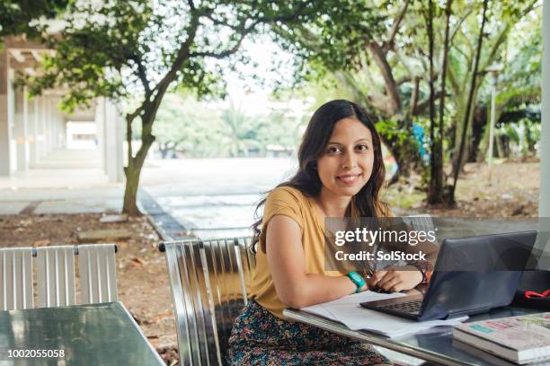 female student studying outside with her laptop - hispanic month stock pictures, royalty-free photos & images