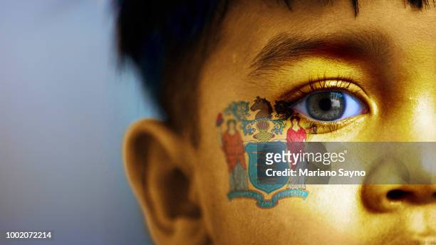 boy's face, looking at camera, cropped view with digitally placed new jersey state flag on his face. - mid atlantic bundesstaaten der usa stock-fotos und bilder