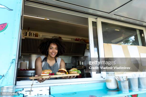 African woman vending burgers in food truck