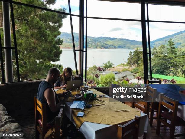 couple of people working on personal computers over breakfast on a conference in a rural location - colombia business breakfast meeting stock pictures, royalty-free photos & images
