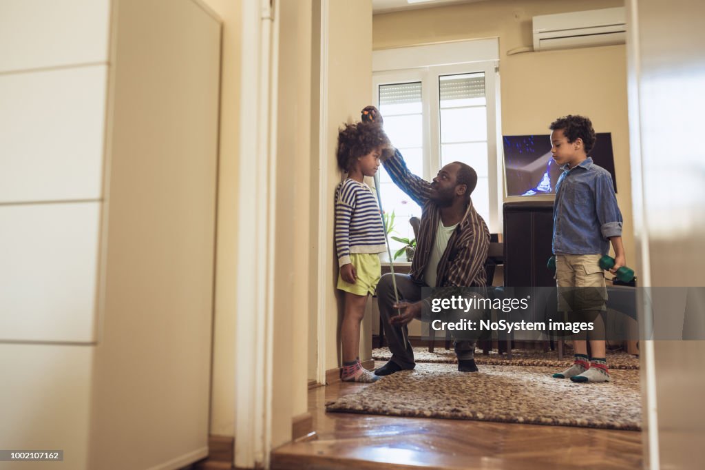 Father measuring daughter height