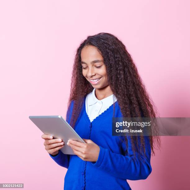 portrait of happy afro amercian schoolgirl using digital tablet - student coloured background stock pictures, royalty-free photos & images