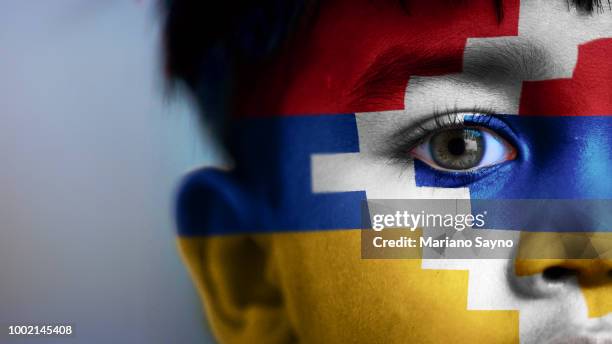 boy's face, looking at camera, cropped view with digitally placed artsakh flag on his face. - nagorno karabakh stock pictures, royalty-free photos & images