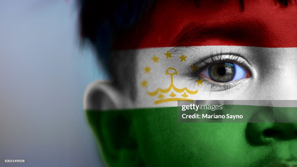 Boy's face with digitally placed Tajikistan flag on his face.