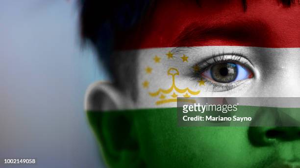boy's face with digitally placed tajikistan flag on his face. - dushanbe stock pictures, royalty-free photos & images