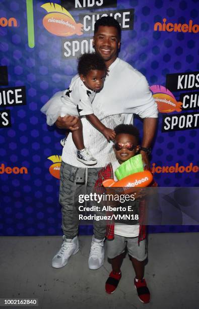 Player Russell Wilson, winner of the Best Cannon award, Sienna Princess Wilson and Future Zahir Wilburn pose backstage at the Nickelodeon Kids'...