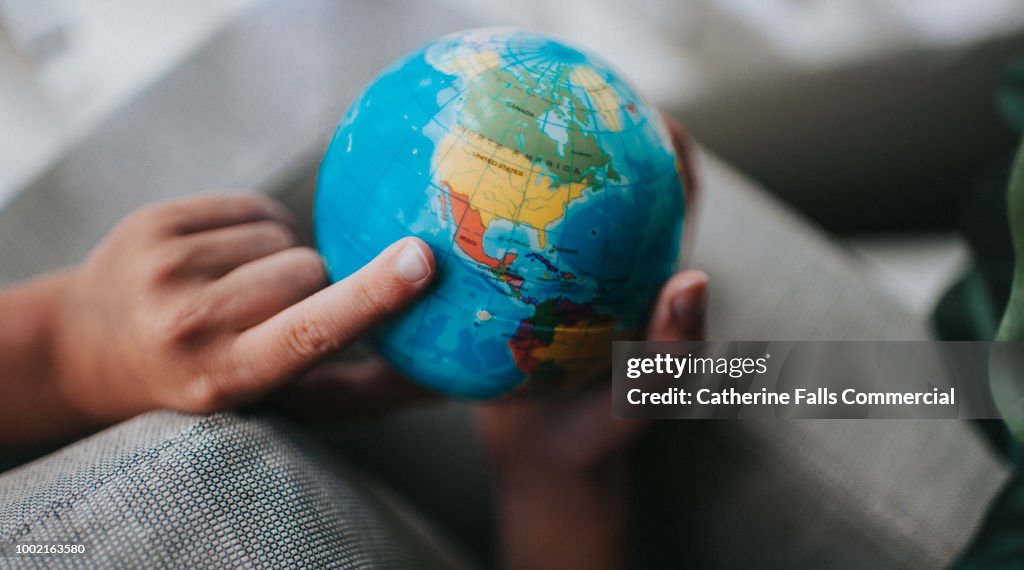 Child pointing to a globe