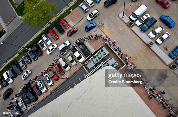 People wrap around the parking lot of a hotel as they wait in line at a job fair for SmartCo Foods in Denver, Colorado, U.S., on Thursday, May 20,...