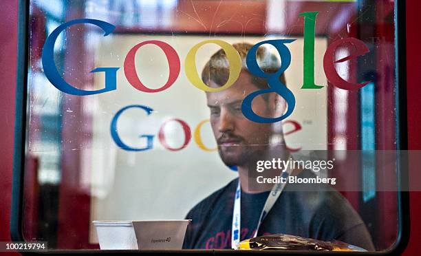 An attendee stands inside a YouTube.com upload booth during the Google I/O Developers' Conference in San Francisco, California, U.S., on Thursday,...