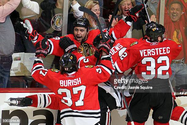 Dustin Byfuglien of the Chicago Blackhawks reacts with teammates Jonathan Toews, Adam Burish and Kris Versteeg after Byfuglien scores the...