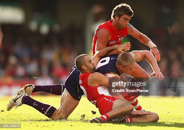 Adam McPhee of the Dockers is tackled by Brett Kirk and Rhyce Shaw of the Swans during the round nine AFL match between the Sydney Swans and the...