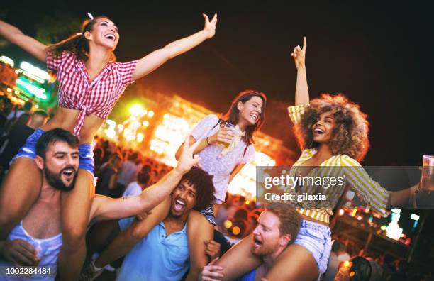 friends dancing at a concert. - on shoulders at concert stock pictures, royalty-free photos & images