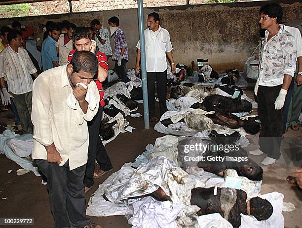 Relatives look at charred bodies following a plane crash, on May 22, 2010 in Mangalore. An Air India Express Boeing 737-800 series aircraft overshot...