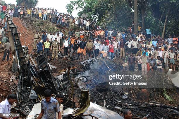 Onlookers watch firemen and paramilitary personnel conduct rescue work at the airline crash site, on May 22, 2010 in Mangalore. An Air India Express...