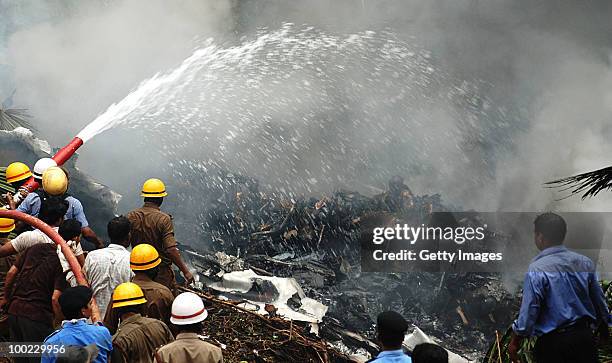 Firemen hose down the smoldering wreckage following a plane crash, on May 22, 2010 in Mangalore. An Air India Express Boeing 737-800 series aircraft...